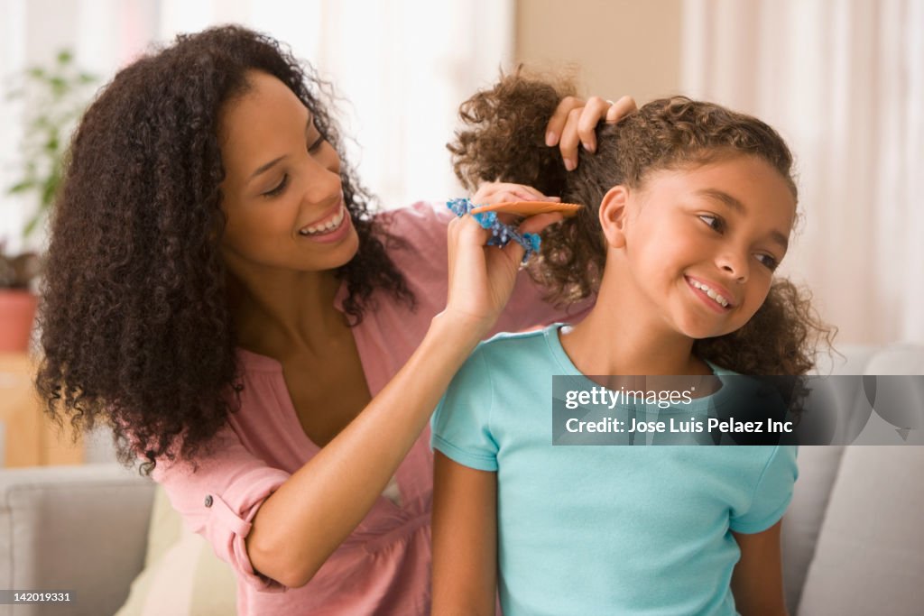 Mixed race mother brushing daughter's hair