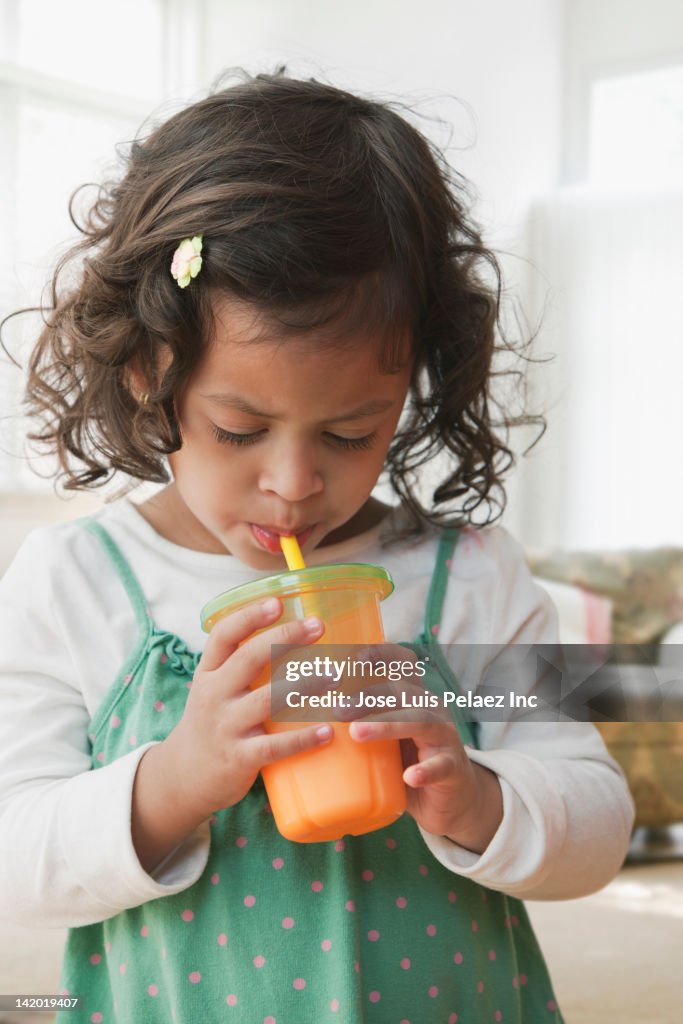 Hispanic girl drinking juice