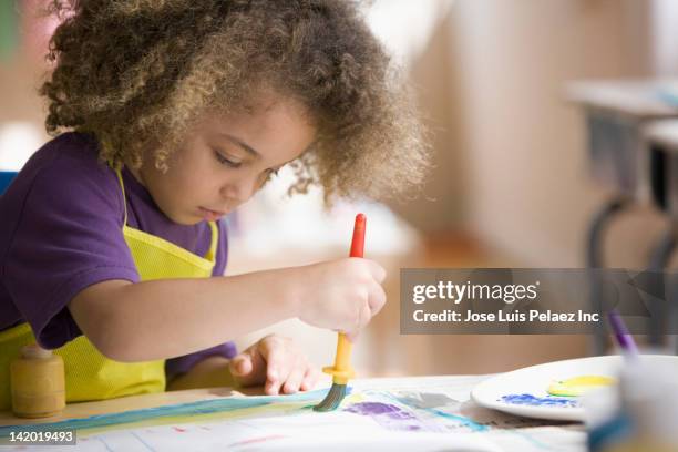 mixed race boy painting picture - child painting stock-fotos und bilder