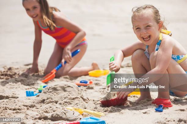 caucasian girls playing in sand - children only stock-fotos und bilder