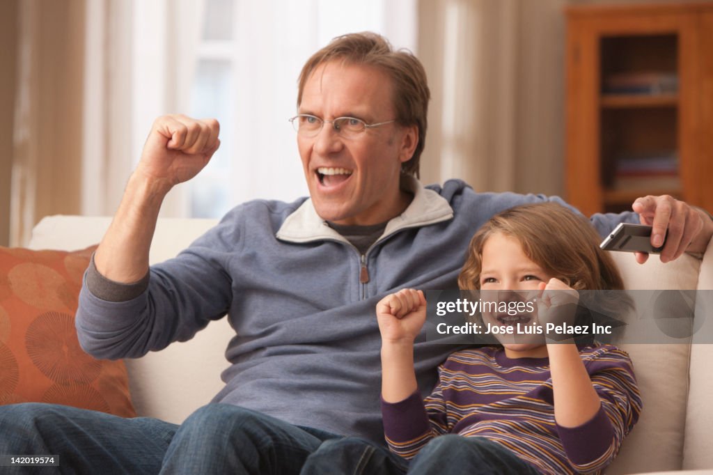 Caucasian father and son watching television