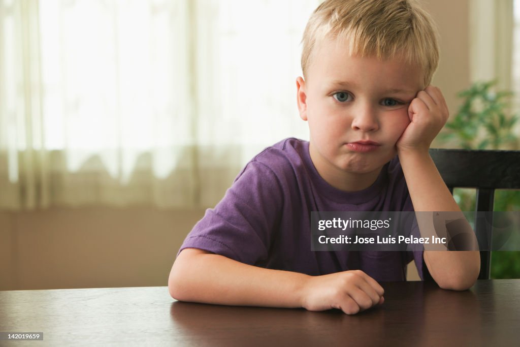 Frustrated Caucasian boy with head in  hands