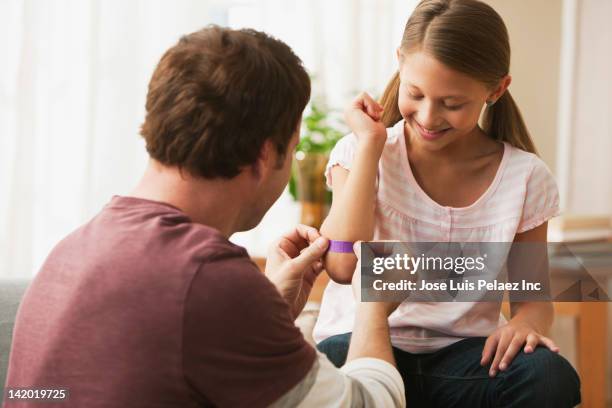 caucasian father putting bandage on daughter - applying bandaid stock pictures, royalty-free photos & images