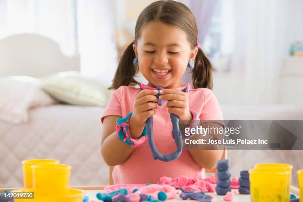 caucasian girl playing with clay - klei stockfoto's en -beelden
