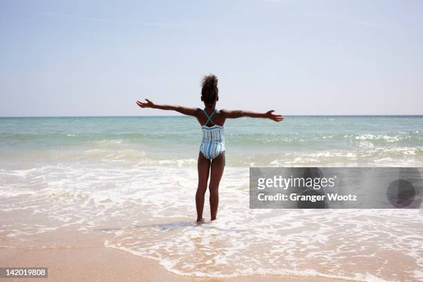 jamaican girl wading on beach - african girls on beach stockfoto's en -beelden