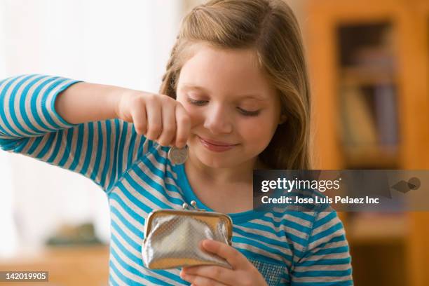 caucasian girl putting coin into purse - zakgeld stockfoto's en -beelden