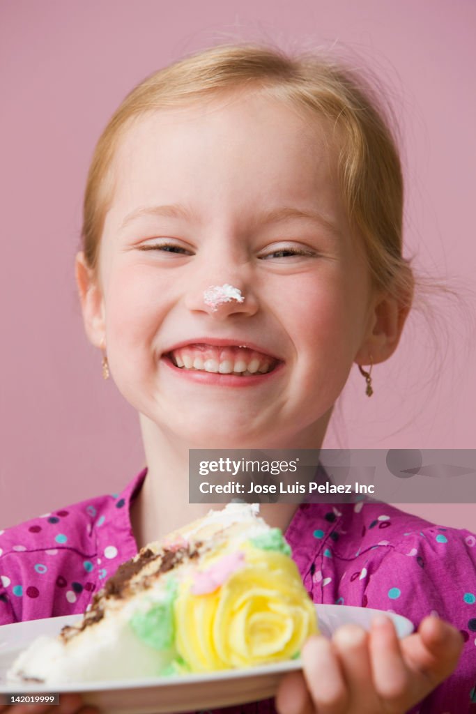 Grinning girl with birthday cake icing on her nose