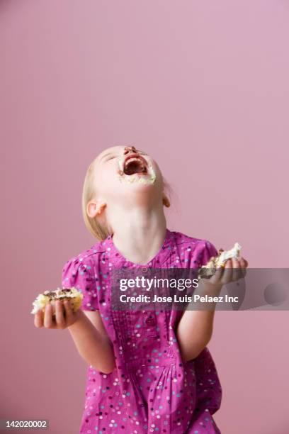 messy girl holding birthday cake - eating cake stock-fotos und bilder