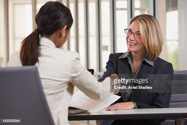 businesswomen shaking hands - back shot position stock pictures, royalty-free photos & images