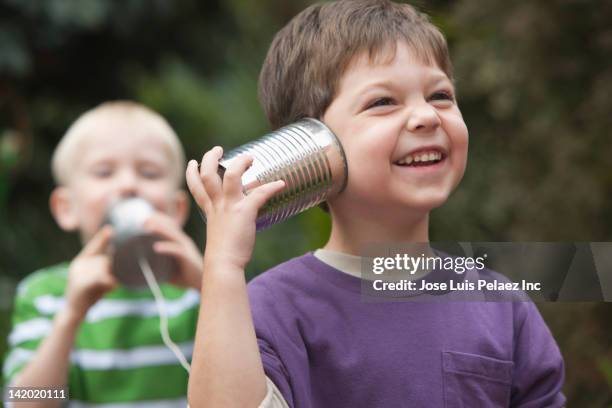 caucasian boys playing with tin can telephone - plåtburkstelefon bildbanksfoton och bilder