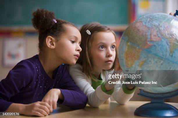students looking at globe in classroom - physical geography fotografías e imágenes de stock