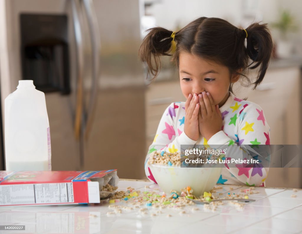 Caucasian girl spilling cereal