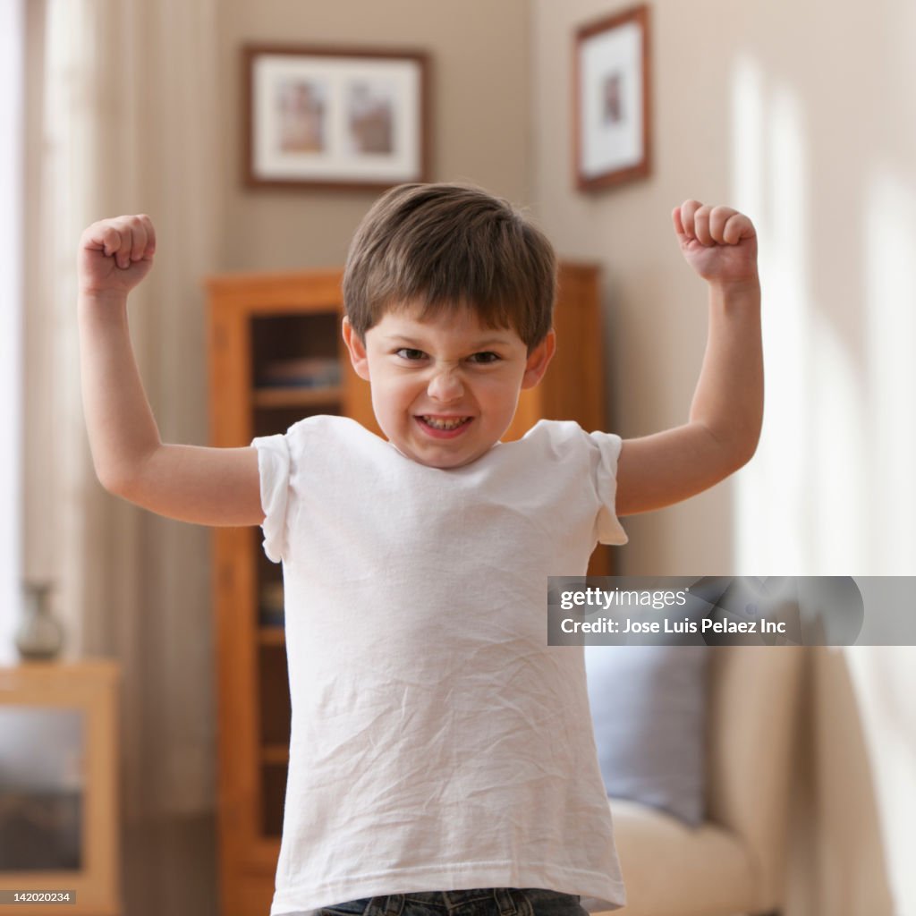 Caucasian boy flexing muscles