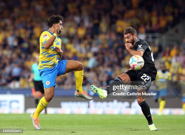 Manuel Pherai of Eintracht Braunschweig tackles Enrico Valentini of 1. FC Nürnberg during the Second Bundesliga match between Eintracht Braunschweig...