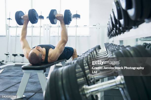 middle eastern man exercising with dumbbells - weight bench stock pictures, royalty-free photos & images