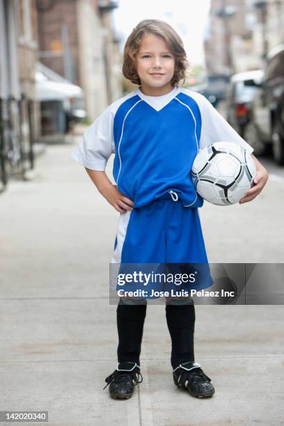 caucasian boy in soccer uniform holding ball - soccer uniform foto e immagini stock