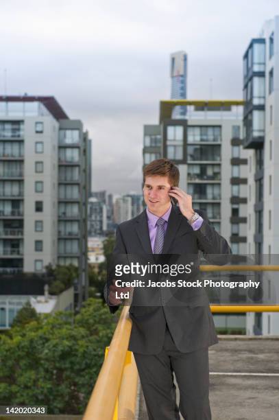 caucasian businessman using cell phone on city rooftop - melbourne rooftop parking ストックフォトと画像