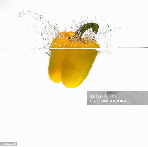bell pepper splashing in water - gele paprika stockfoto's en -beelden