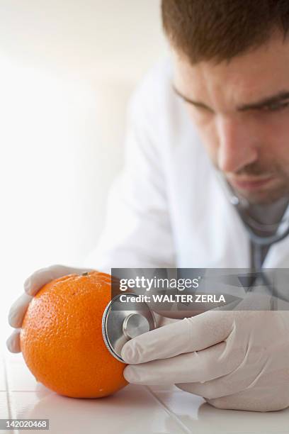 scientist using stethoscope on orange - prélèvement à tester photos et images de collection