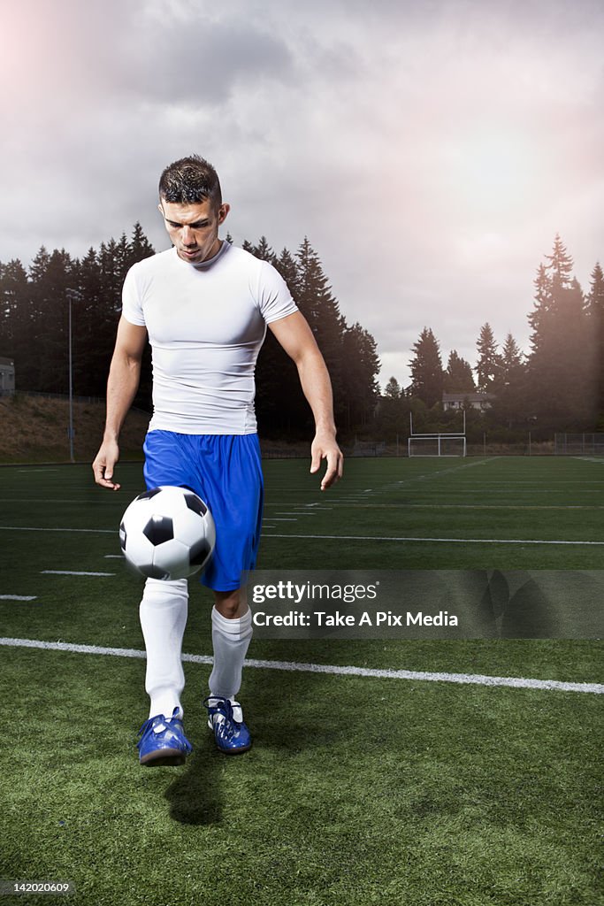 Hispanic athlete kicking soccer ball