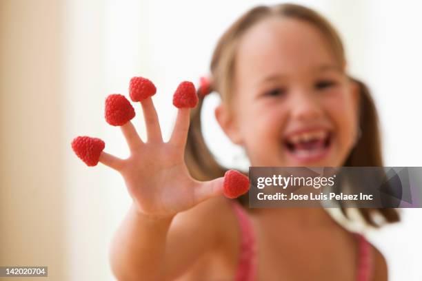 girl putting raspberries on fingers - west new york new jersey stock-fotos und bilder