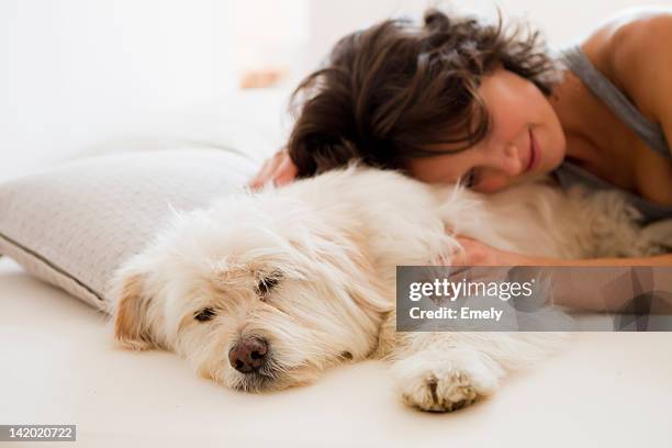woman relaxing with dog in bed - female sleeping stock pictures, royalty-free photos & images