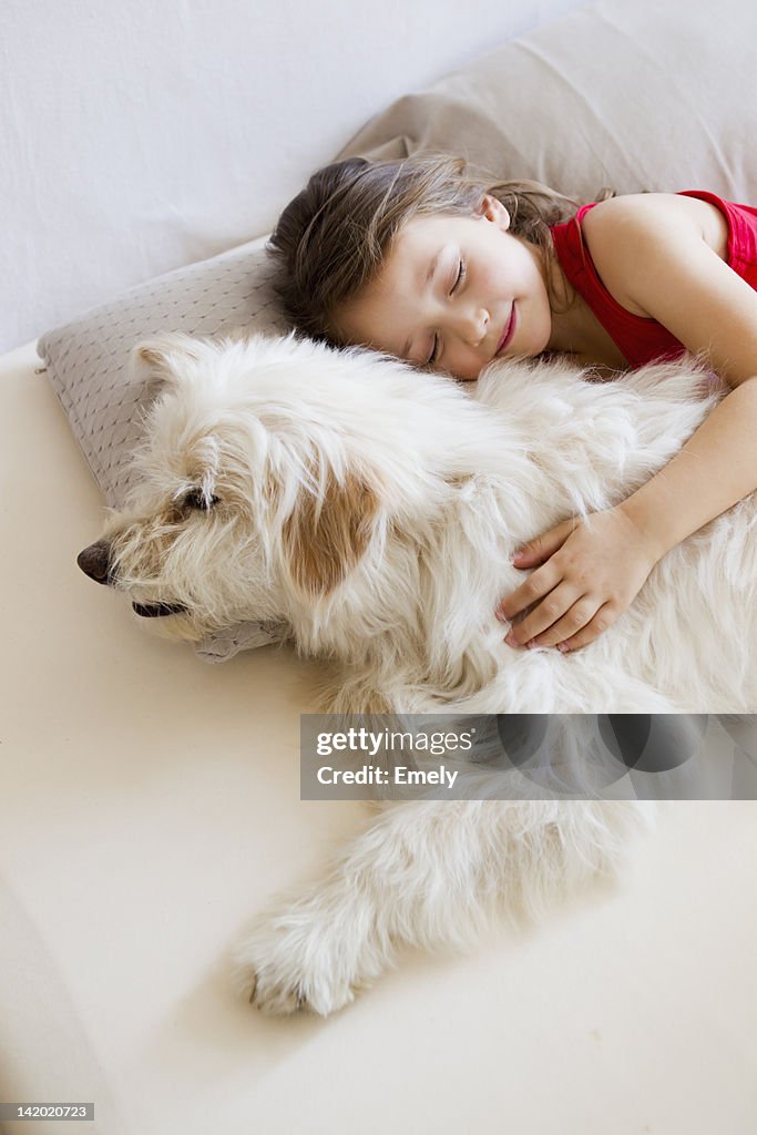 Girl relaxing with dog in bed