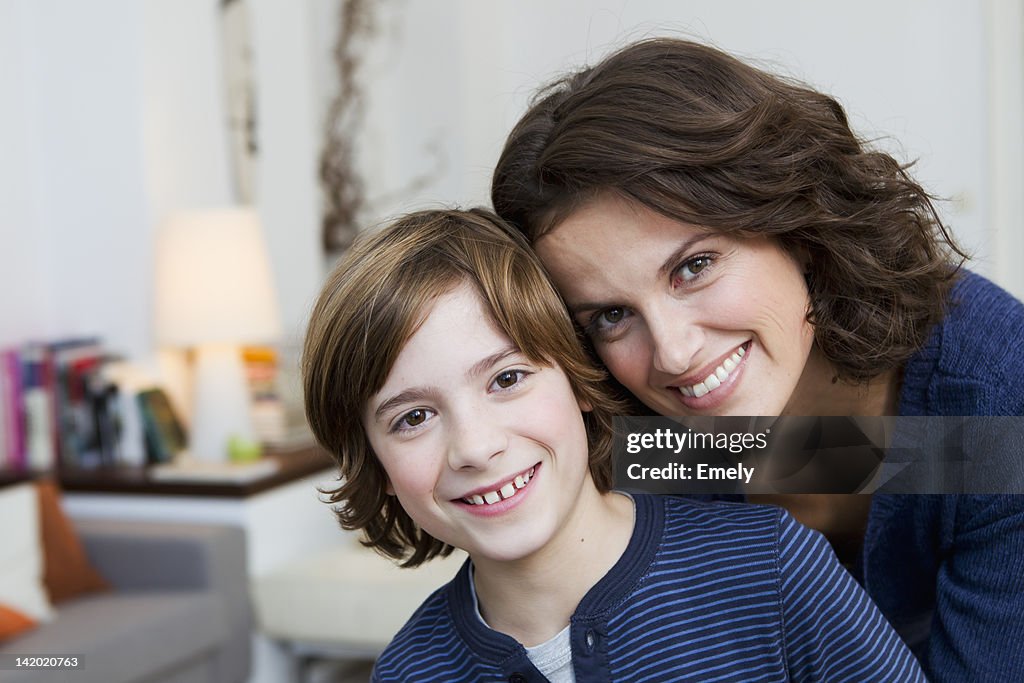 Mutter und Sohn umarmen im Wohnzimmer