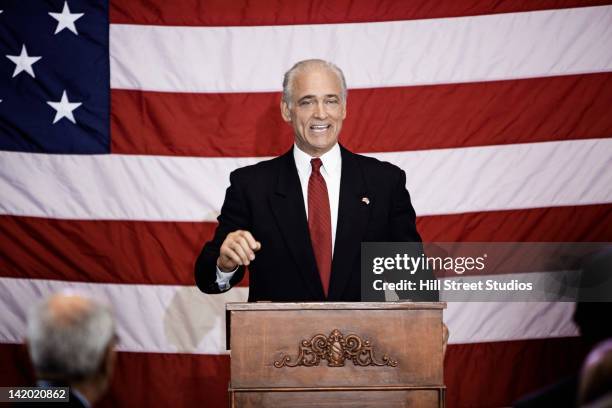 caucasian politician making a speech at podium - politician stock-fotos und bilder