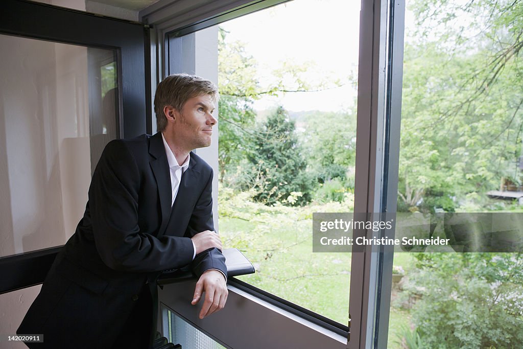 Businessman looking out office window