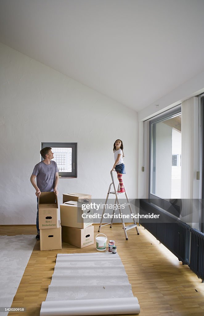Father and daughter painting new house