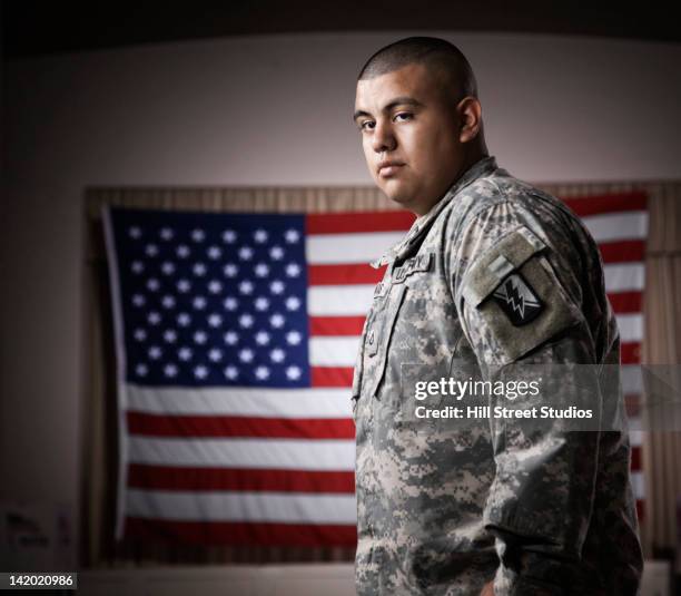 hispanic soldier standing in front of american flag - united states marine corps stockfoto's en -beelden