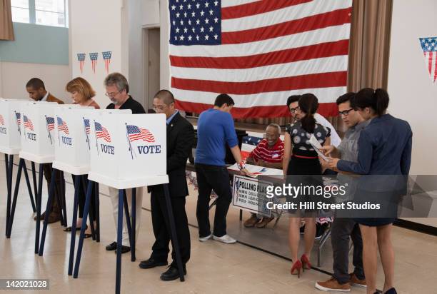 people voting in polling place - election day fotografías e imágenes de stock