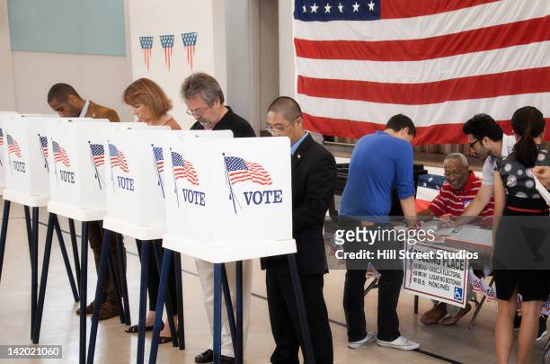 people voting in polling place - local de votação imagens e fotografias de stock