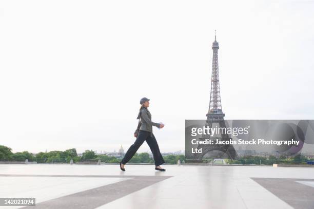 hispanic woman walking near the eiffel tower - day to the liberation of paris photos et images de collection