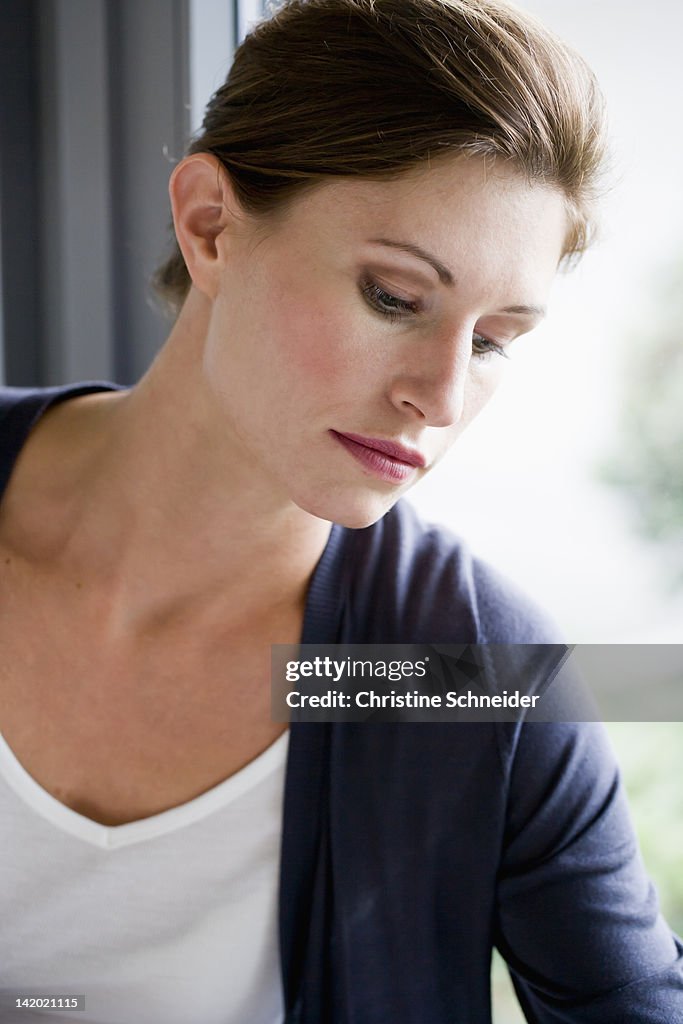 Close up of woman leaning on window