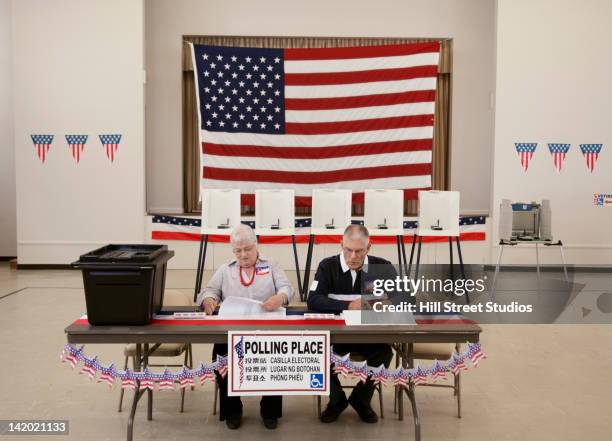 caucasian man and woman working at polling place - estação eleitoral - fotografias e filmes do acervo