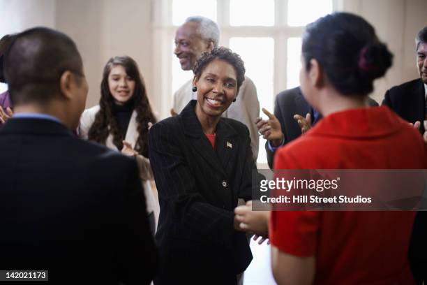 black politician shaking hands with supporters - politician stockfoto's en -beelden