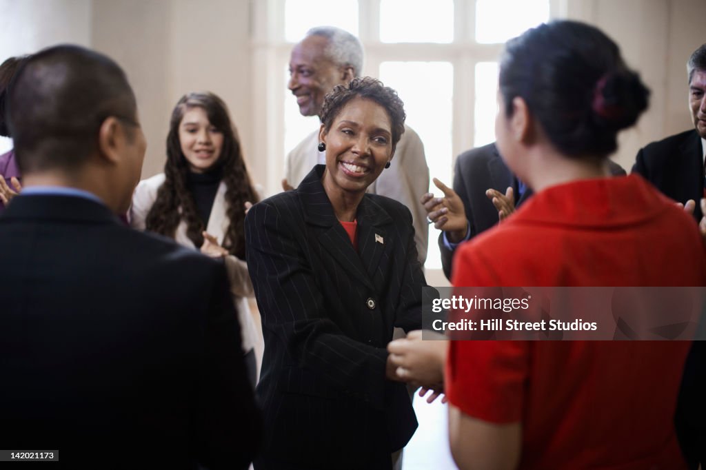 Black politician shaking hands with supporters