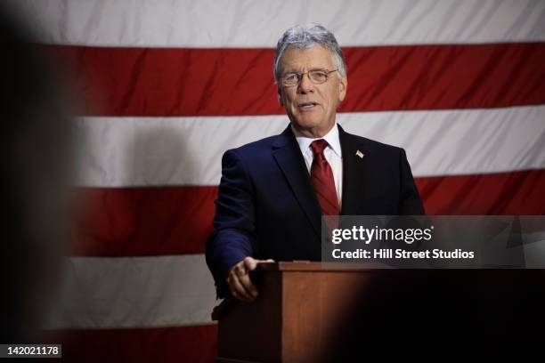 caucasian politician making speech at podium - politician speaking stock pictures, royalty-free photos & images