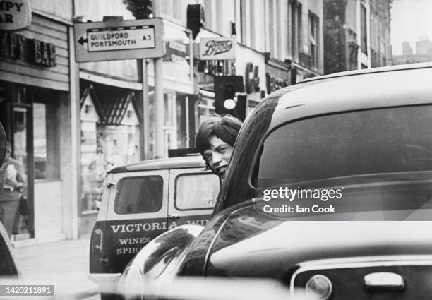 English Rock singer Mick Jagger smiles out of the window of a car as it drives away, London, England, 1967. He had just been released from Brixton...
