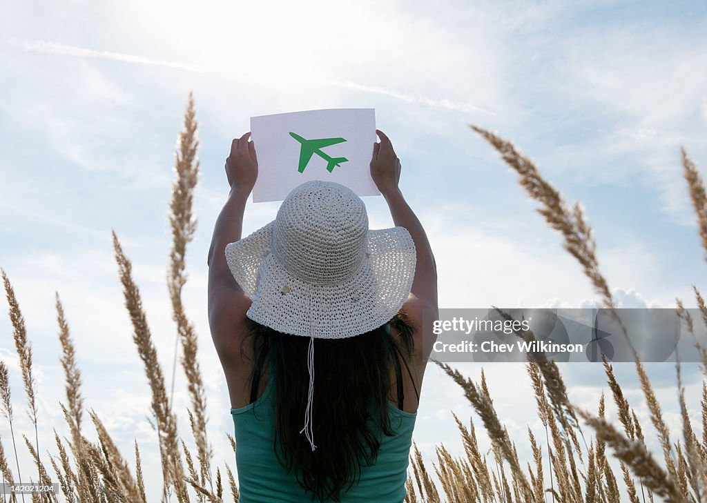 Mulher a segurar panorama de avião no céu