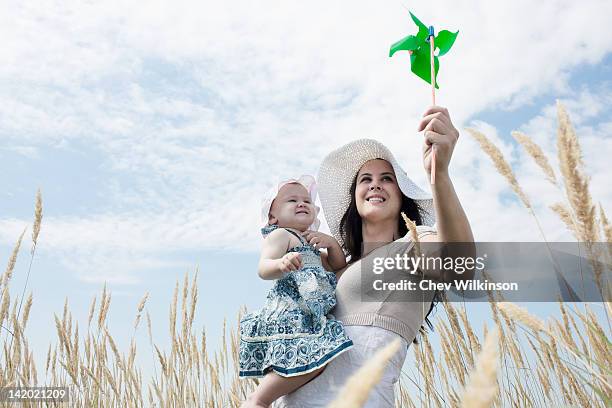 woman holding pinwheel for daughter - dedication stock pictures, royalty-free photos & images