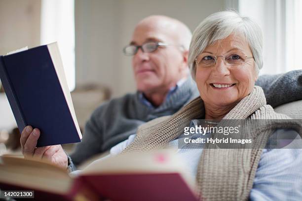 lächelnd ältere paar lesen bücher - 50 54 jahre stock-fotos und bilder