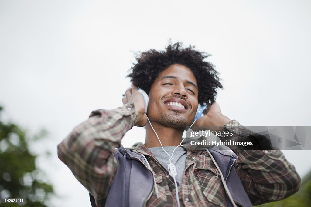 Man listening to headphones outdoors