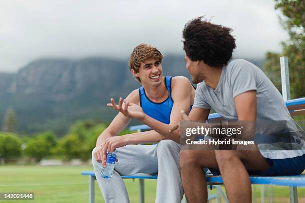 men talking on bleachers in park - student athlete stock pictures, royalty-free photos & images