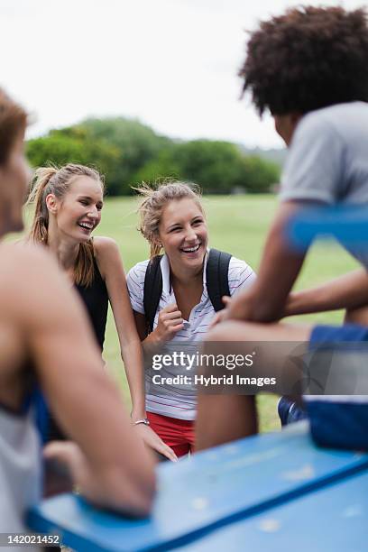 friends talking on bleachers in park - college athletics stock pictures, royalty-free photos & images