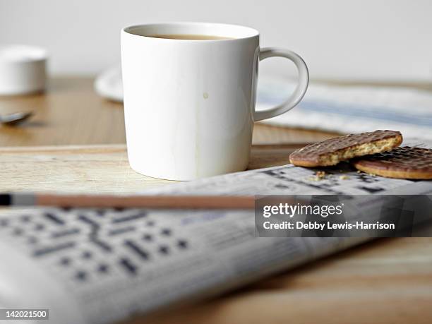 "tea, cookies and crossword on board" - newspaper on table ストックフォトと画像