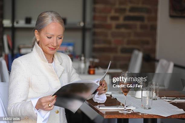 older woman reading magazine in cafe - glass magazine stock pictures, royalty-free photos & images