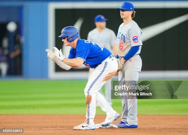 Matt Chapman of the Toronto Blue Jays celebrates a double in front of Zach McKinstry of the Chicago Cubs in the sixth inning during their MLB game at...